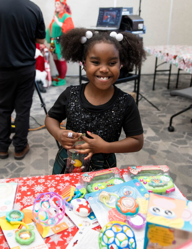 Araina Frazier smiling with holiday gifts and cards