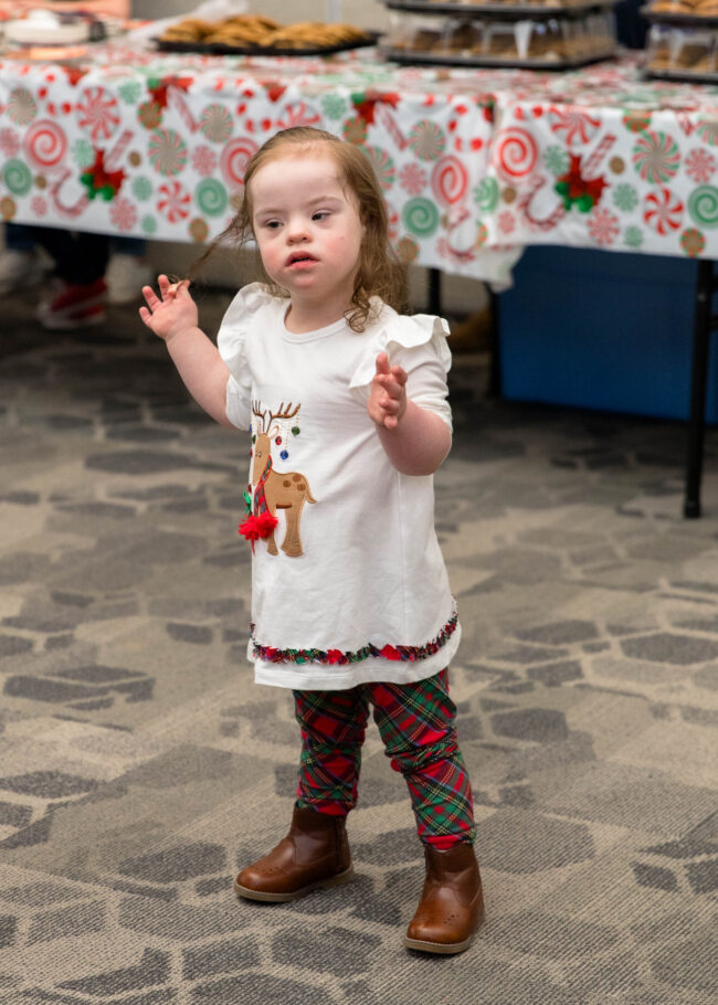 Gracelyn Sammon in a reindeer dress beside the cookie table
