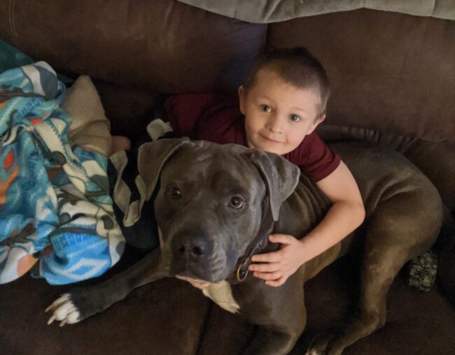 Westin snuggled up on the sofa with his dog Gronk