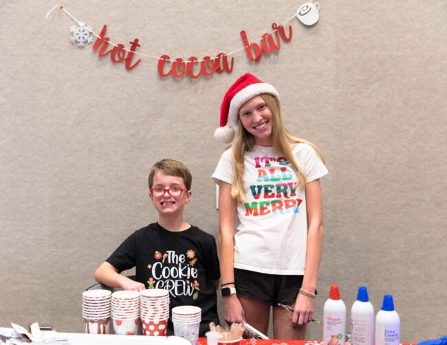 Young volunteers running the hot cocoa bar at the Cookies with Santa party