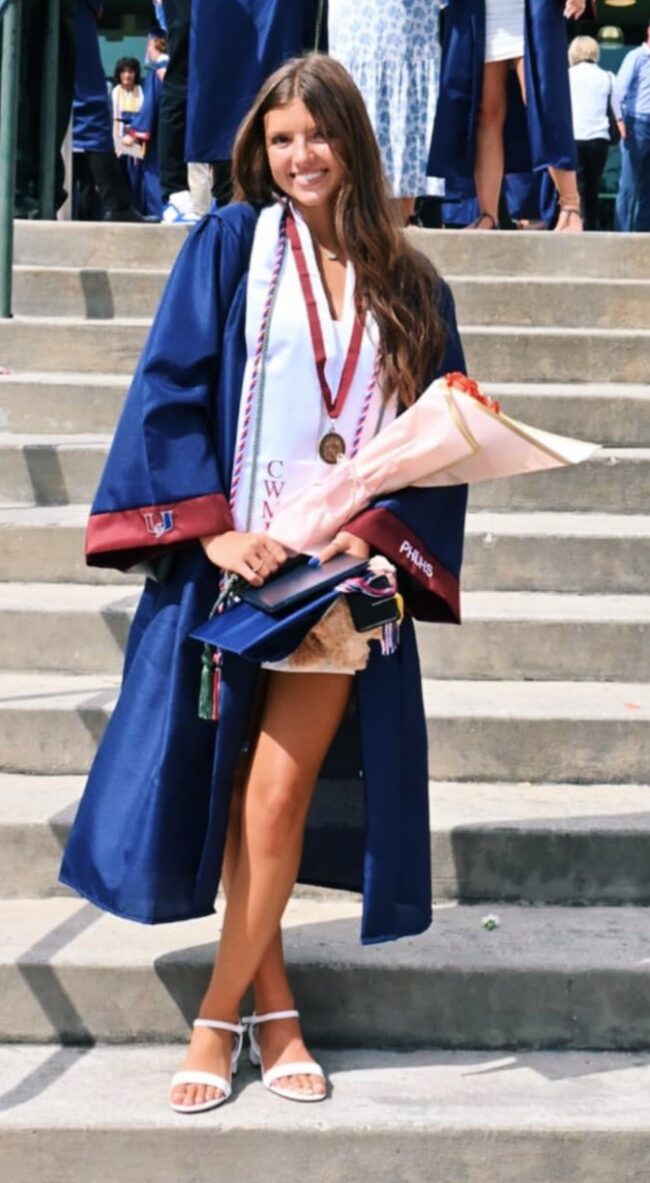 Makena Diebold in a graduation gown holding flowers